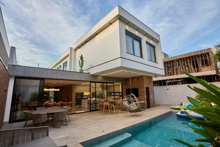 A contemporary luxury home with a pool and outdoor seating, showcasing modern architecture.